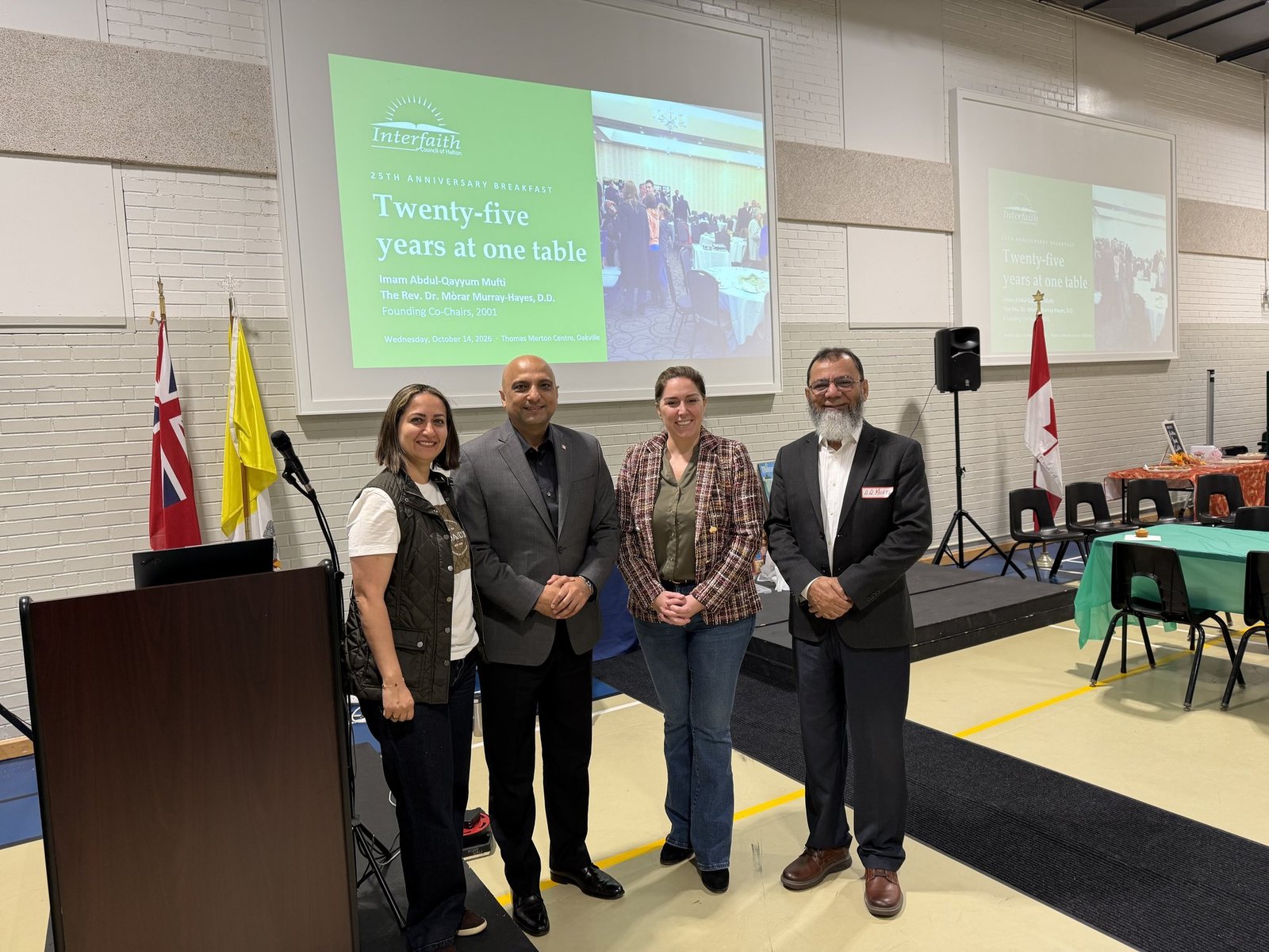 Imam Abdul-Qayyum Mufti with guests, in front of the title slide of the morning’s presentation, Twenty-five years at one table